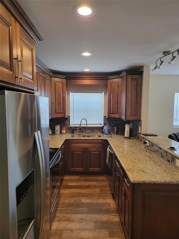 An empty room features wood-look tile flooring, a ceiling fan, and a window with blinds — 2131 W BAY DRIVE UNIT B, LARGO, FL