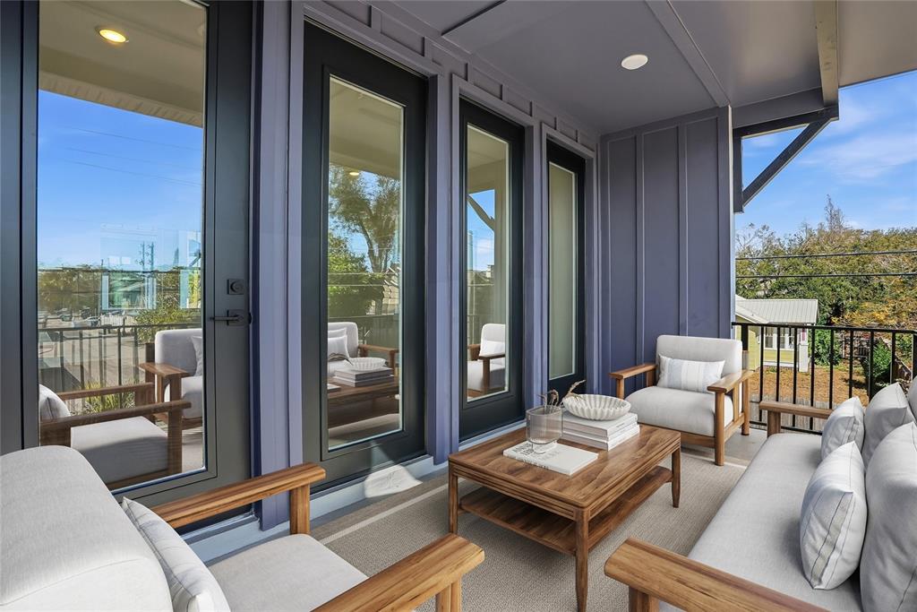 A covered balcony features dark blue siding, glass doors, and outdoor seating around a coffee table — 3005 1ST AVENUE N, ST PETERSBURG, FL