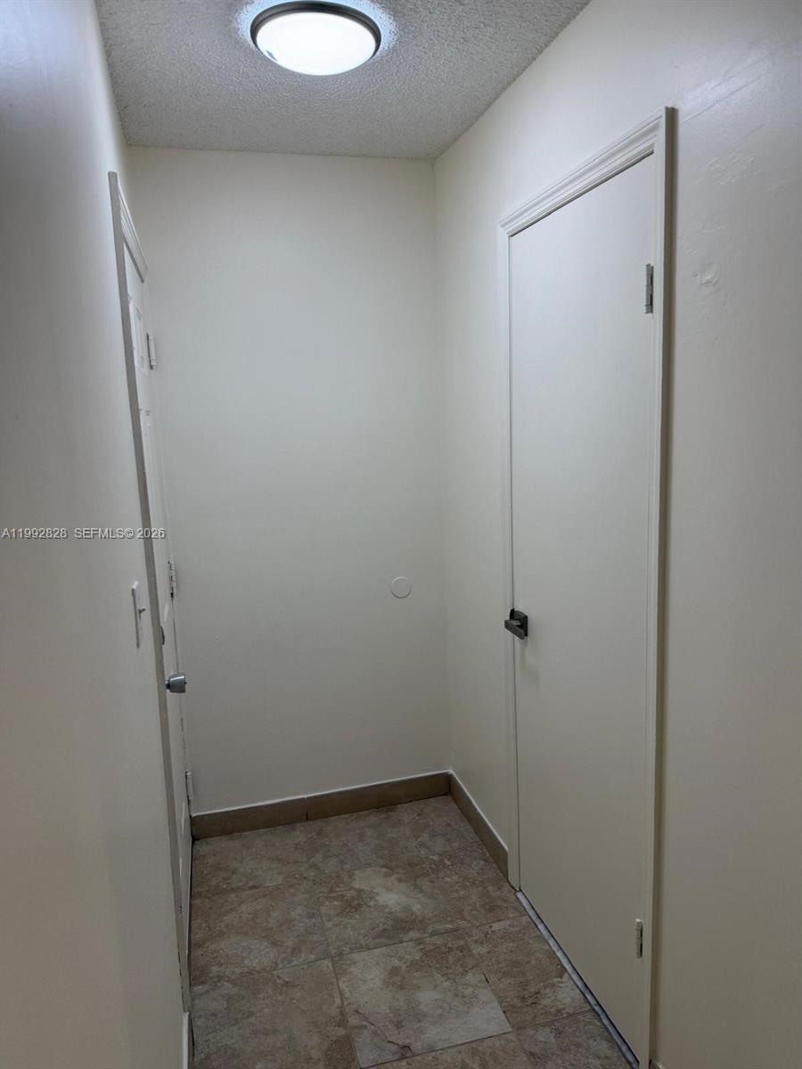 A small hallway features tiled flooring, white walls, and two closed doors — 14907 SW 80th St # 205, Miami FL 33193, MIAMI, FL