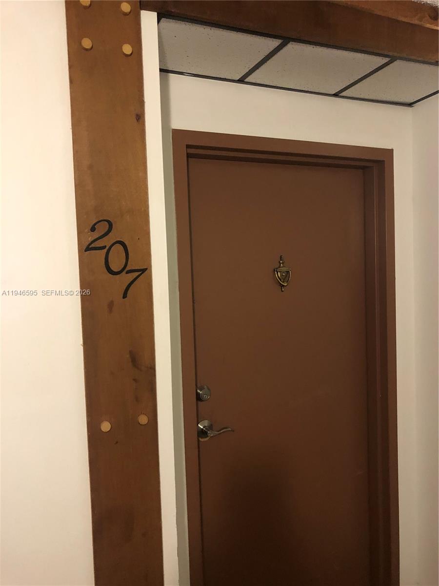 A brown door with a brass knocker is labeled with the number 201 — 210 Lakeview Dr # 207, Weston FL 33326, WESTON, FL