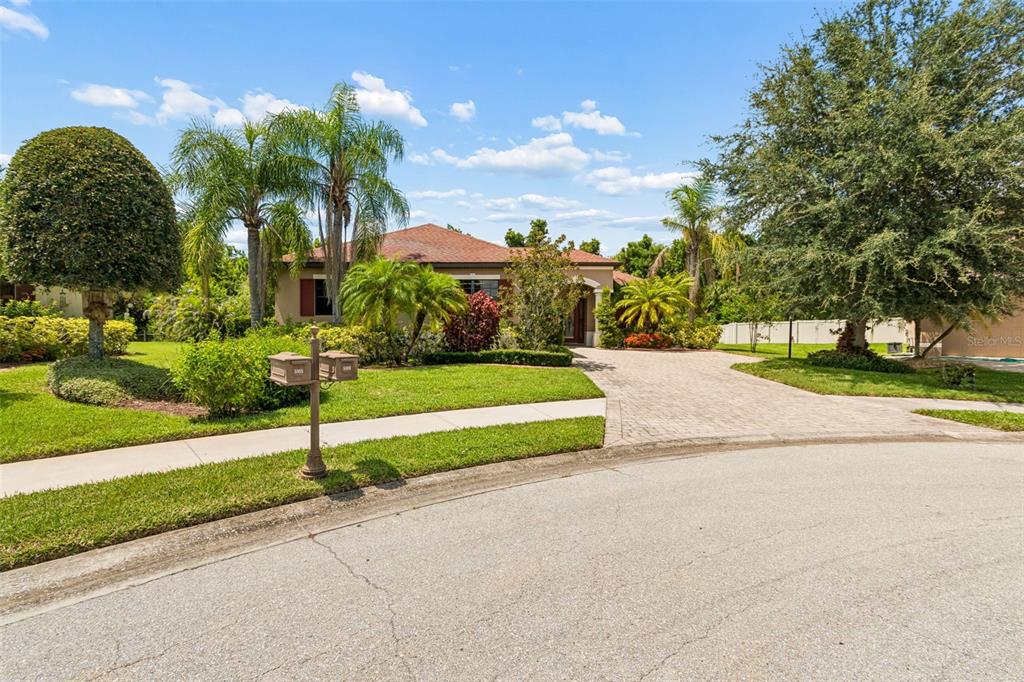 A single-story house with a paved driveway, palm trees, and a manicured lawn — 5919 118TH TERRACE E, PARRISH, FL