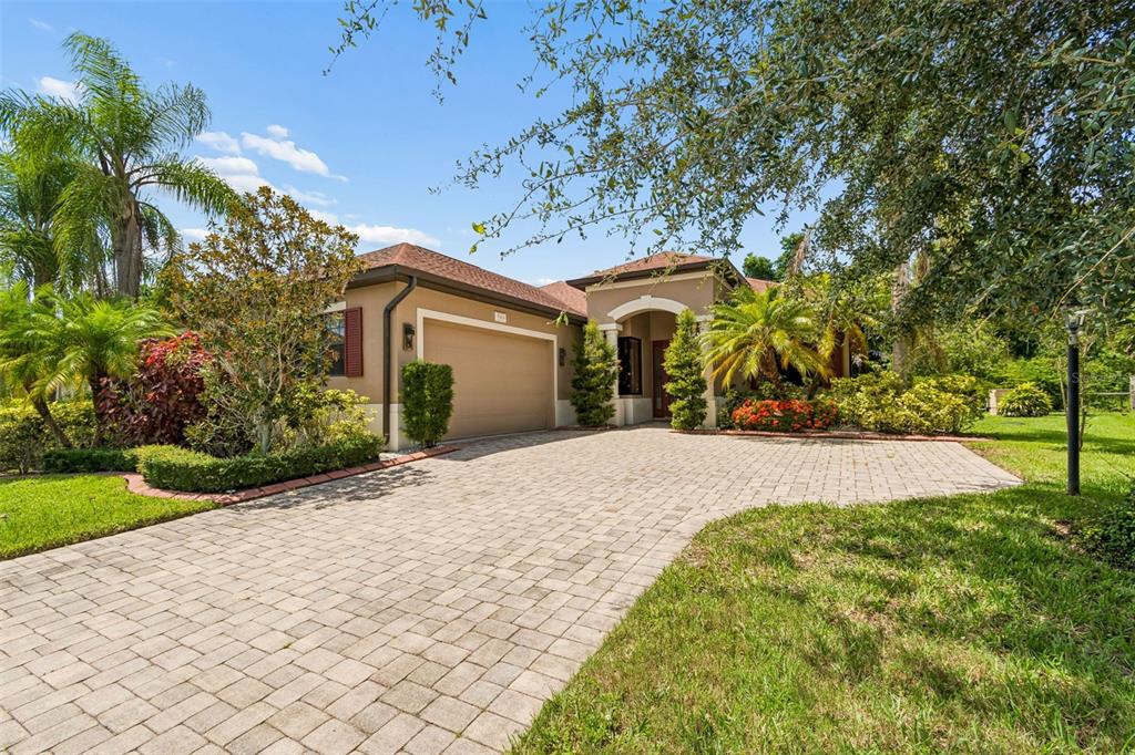 A single-story house with a paved driveway, a two-car garage, and lush landscaping — 5919 118TH TERRACE E, PARRISH, FL