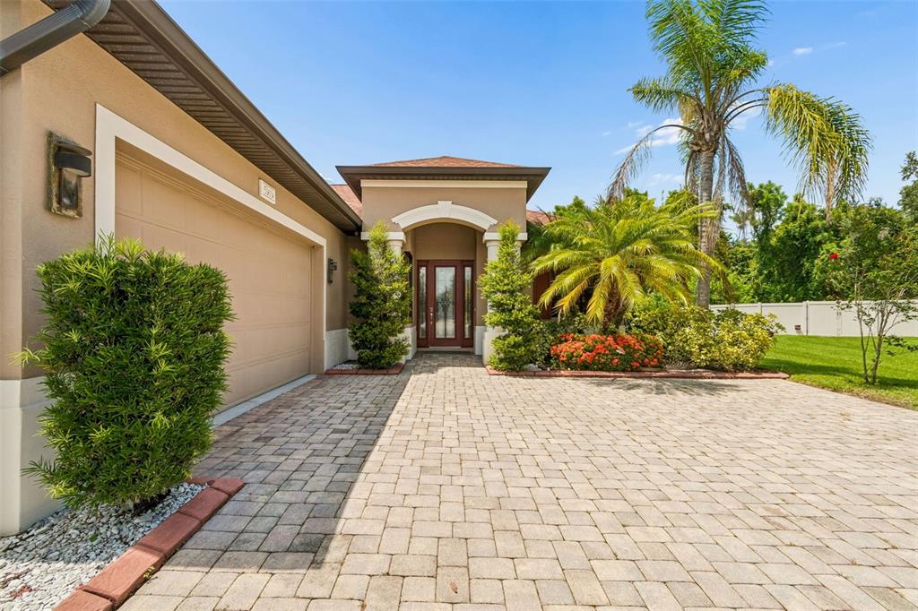 A paved driveway leads to the front entrance of a tan house with a garage — 5919 118TH TERRACE E, PARRISH, FL