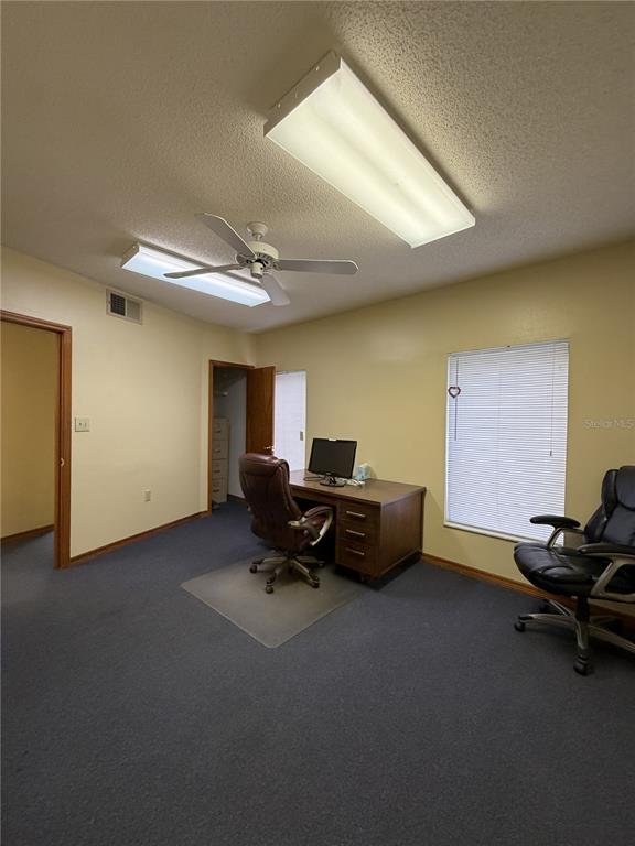 A home office features a wooden desk, two rolling chairs, and a ceiling fan — 1400 W OAK STREET UNIT C1/D2, KISSIMMEE, FL