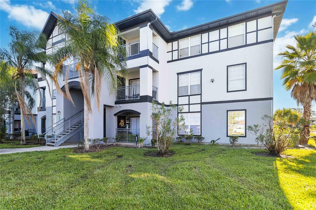A three-story apartment building with white stucco walls, dark trim, and exterior staircases — 3714 PALM DESERT LANE UNIT 5336, ORLANDO, FL