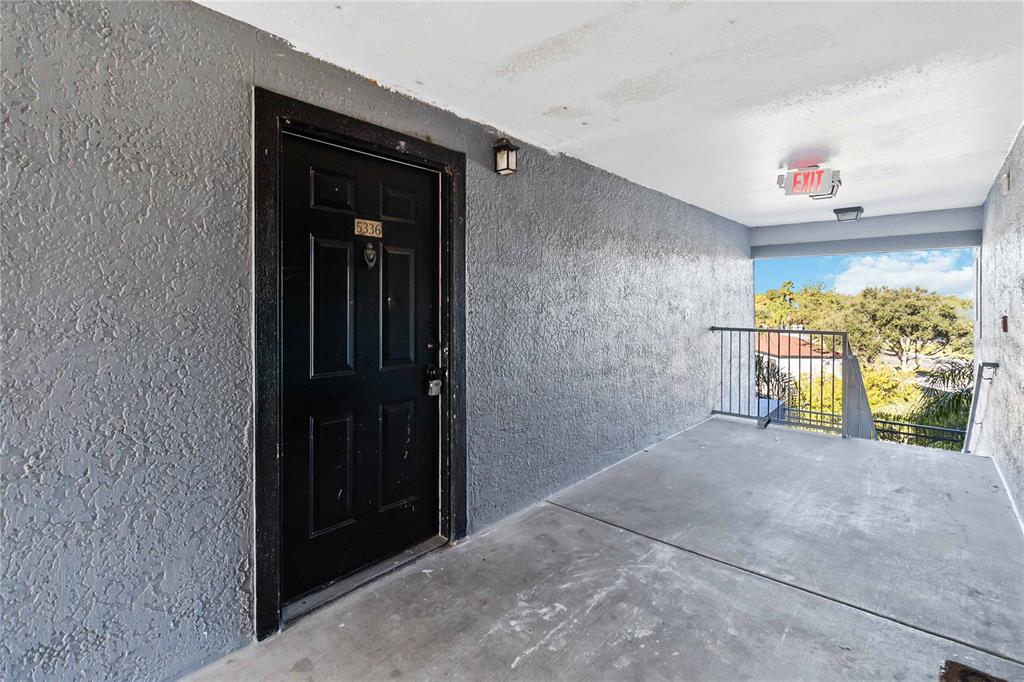 A black front door with the number 5336 is located on a concrete apartment building walkway — 3714 PALM DESERT LANE UNIT 5336, ORLANDO, FL