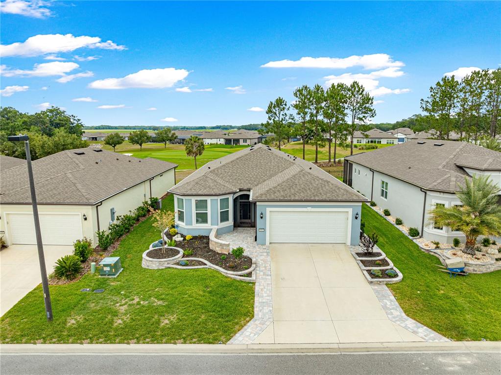 An aerial view shows a single-story suburban house with a paved driveway and landscaped yard — 8983 SW 57TH PLACE ROAD, OCALA, FL