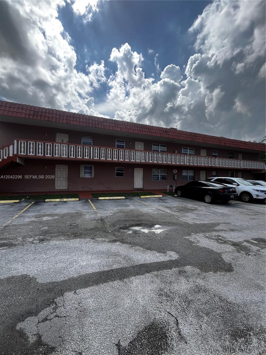 A two-story apartment building features a red tile roof and an exterior walkway — 7830 NW 33rd St # 206, Davie FL 33024, DAVIE, FL