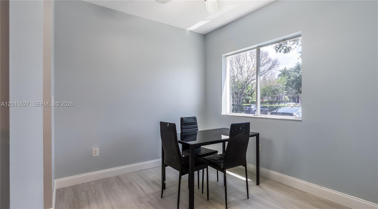 A dining room features light gray walls, wood-look flooring, and a black table with chairs — 7085 Nova Dr # 105, Davie FL 33317, DAVIE, FL