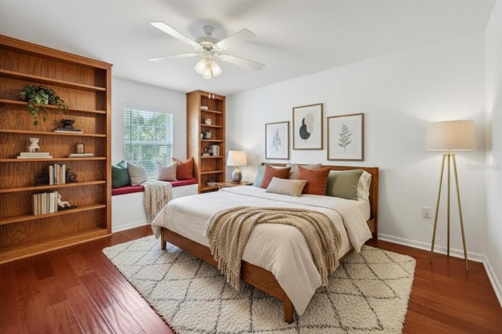 A bedroom features a wooden bed, built-in bookshelves, a window seat, and a white area rug — 4842 WELLBROOK DRIVE, NEW PORT RICHEY, FL