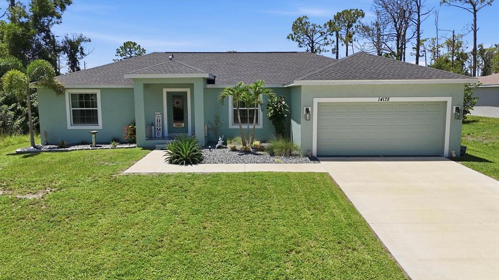A light green single-story house features a dark shingled roof, a garage, and palm trees — 14175 STACKS AVENUE, PORT CHARLOTTE, FL