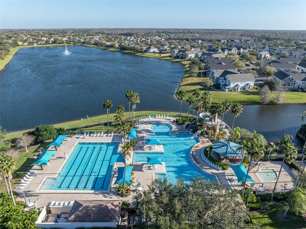 An aerial view shows a community swimming pool complex with a lap pool and water slide — 7438 CHELSEA HARBOUR DRIVE, ORLANDO, FL