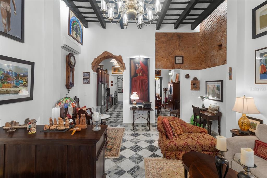 A living room with high ceilings, exposed brick, and black and white checkered marble floors — 422 NORZAGARAY, SAN JUAN, PR