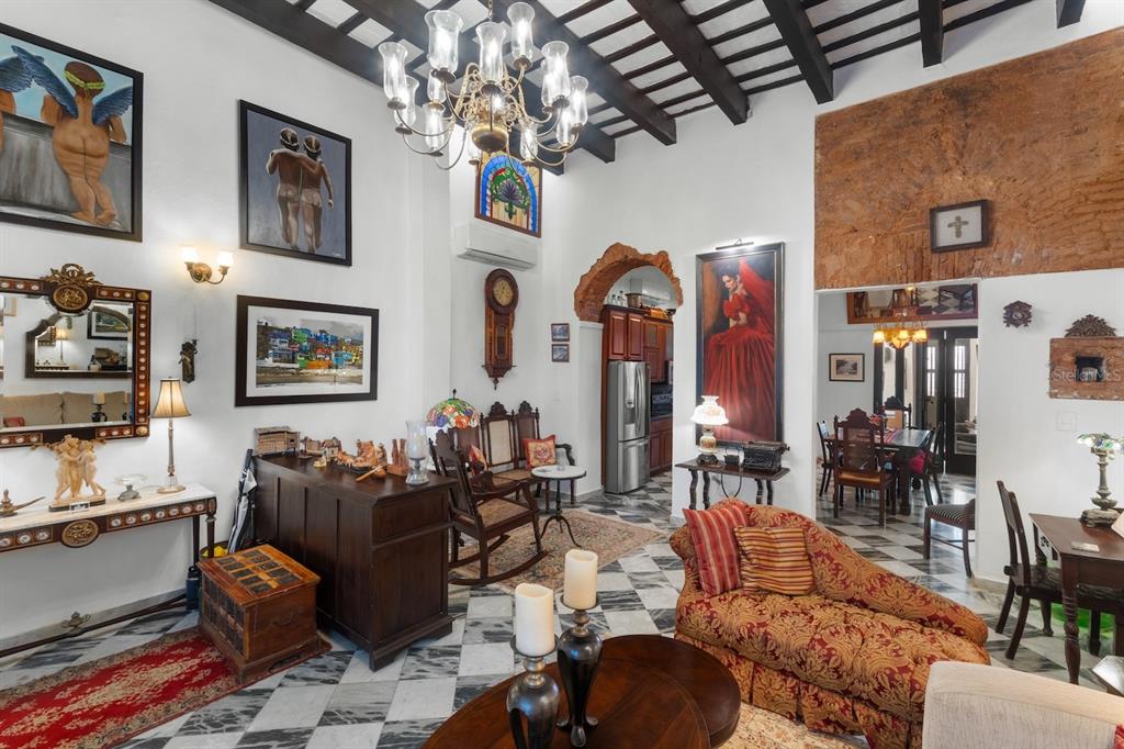 A living room features a high beamed ceiling, marble floors, and eclectic art and furniture — 422 NORZAGARAY, SAN JUAN, PR