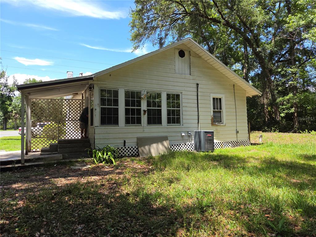 A white, single-story house with a covered porch and lattice skirting sits on a grassy lot — 11280 NE HIGHWAY 314, SILVER SPRINGS, FL