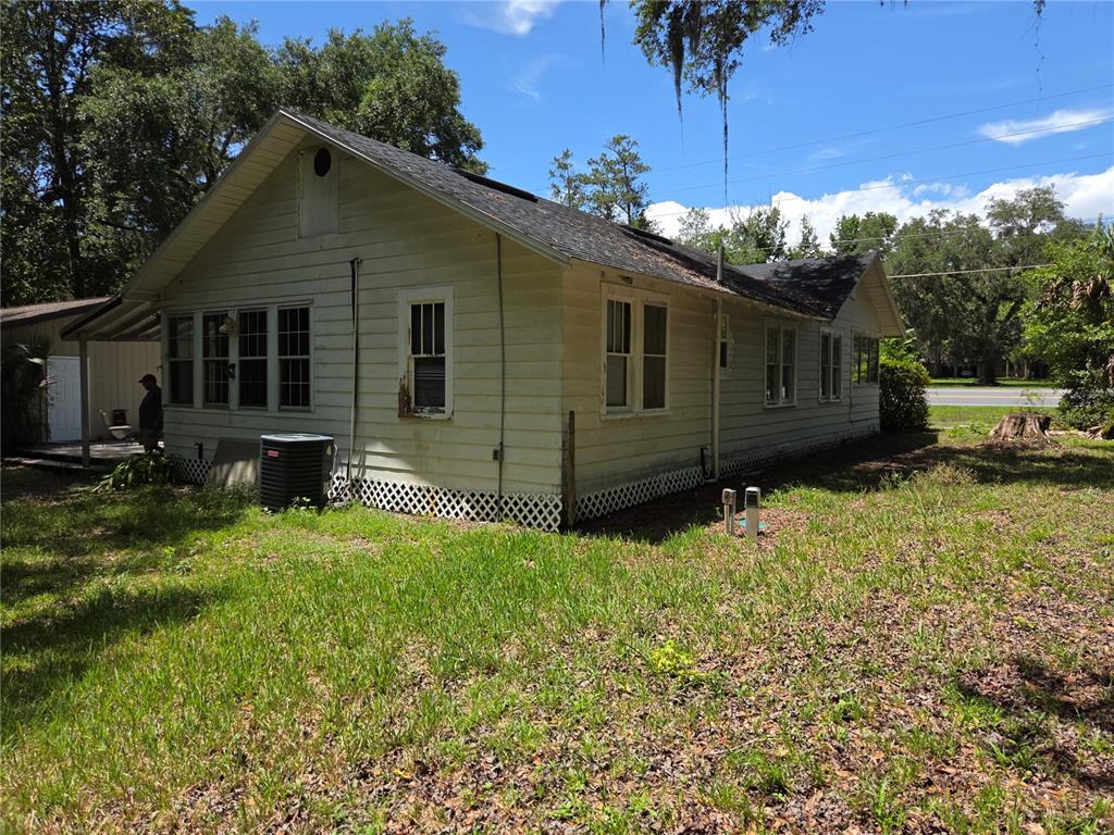 The exterior of a single-story house with white siding and a dark shingled roof — 11280 NE HIGHWAY 314, SILVER SPRINGS, FL