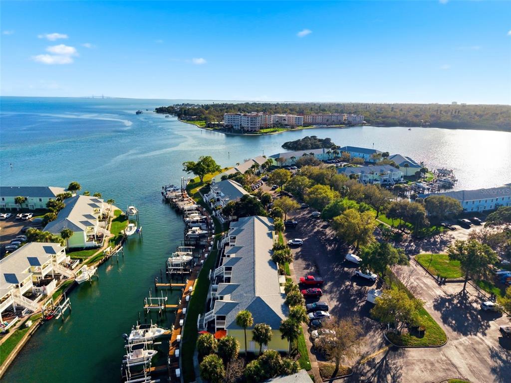 An aerial view shows waterfront condominiums with boat slips along a canal and parking areas — 5174 BEACH DRIVE SE UNIT D, ST PETERSBURG, FL