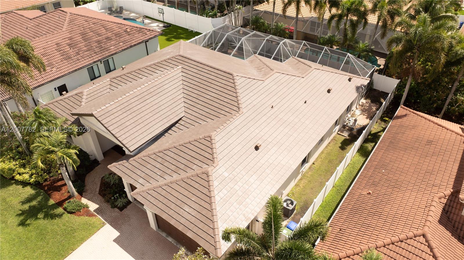 An aerial view shows the tiled roof of a suburban house with a screened pool — 15966 SW 3rd St, Pembroke Pines FL 33027, PEMBROKE PINES, FL
