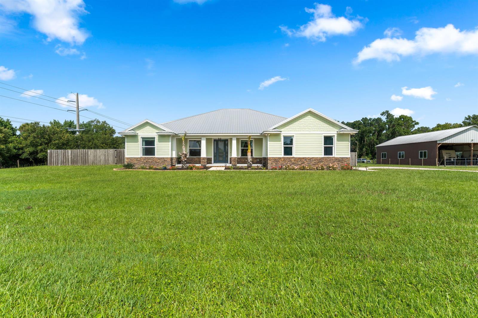 A single-story house with light green siding, a stone base, and a metal roof — 2520 Tammy Drive, Mims FL 32754, MIMS, FL