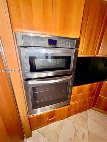 A stainless steel double wall oven is built into wood cabinetry above a storage drawer — 9595 Collins Ave # I, Surfside FL 33154, SURFSIDE, FL