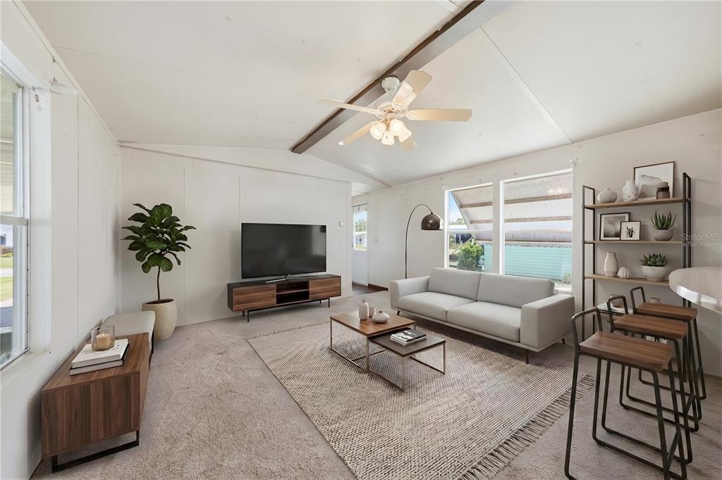 A living room features a television, sofa, coffee tables, and a ceiling fan — 30107 GREEN BAY DRIVE, TAVARES, FL