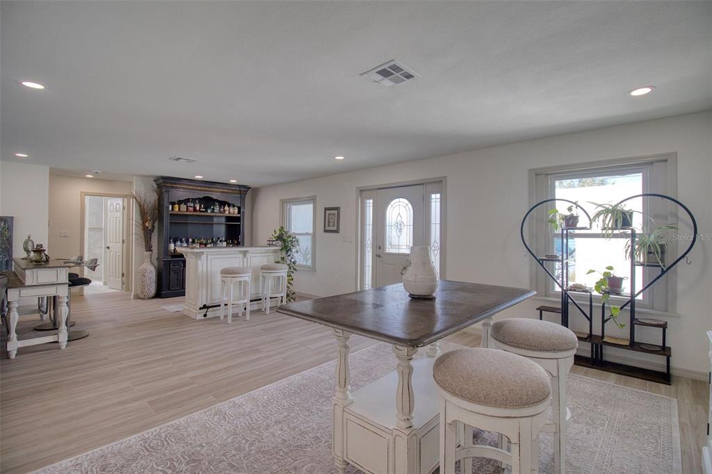 An aerial view shows a waterfront house with a pool enclosure, deck, and boat lift — 13804 PLUMOSA AVENUE, HUDSON, FL