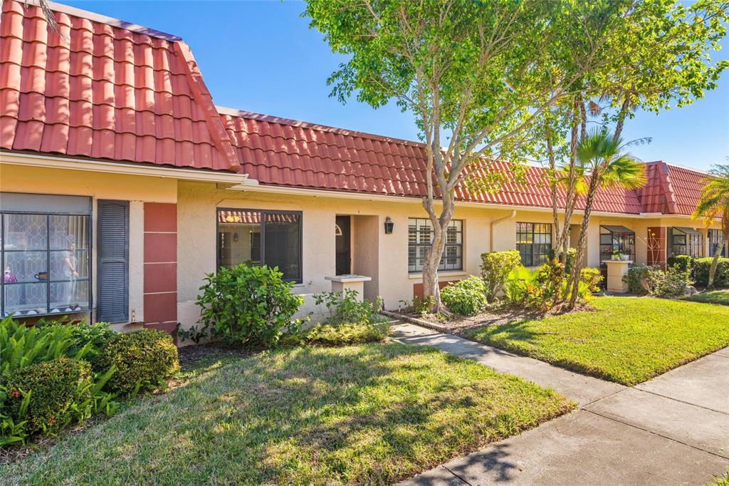 A single-story residential building with a red tile roof and a concrete walkway — 19029 US HIGHWAY 19 HIGHWAY N UNIT 24C, CLEARWATER, FL
