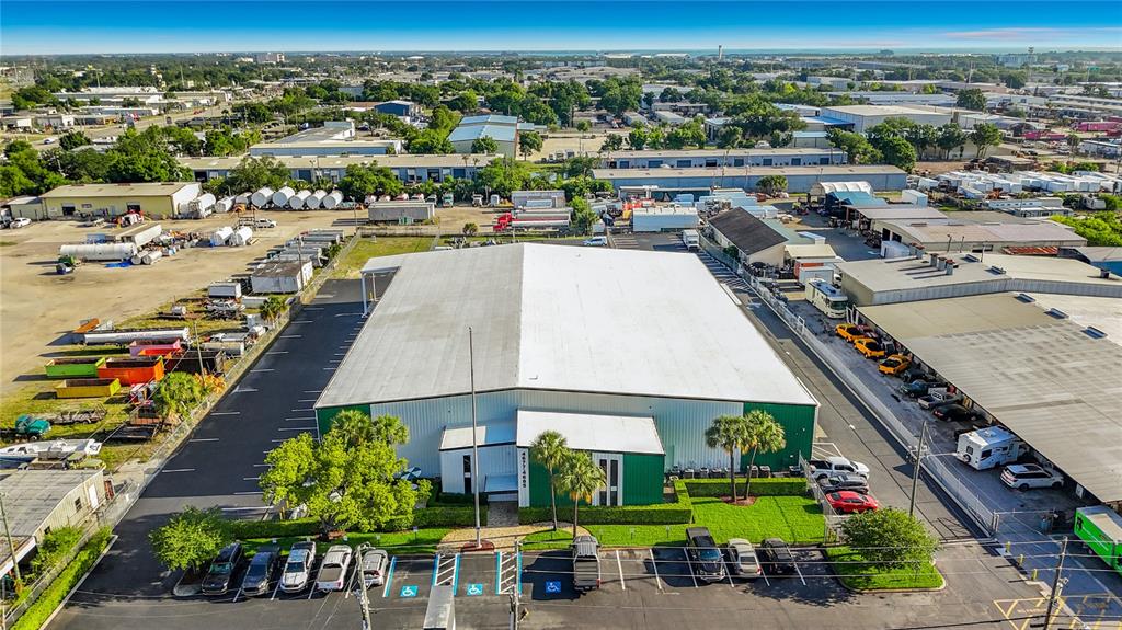 An aerial view shows a large industrial warehouse building with a parking lot and surrounding properties — 4677 118TH AVENUE N, CLEARWATER, FL