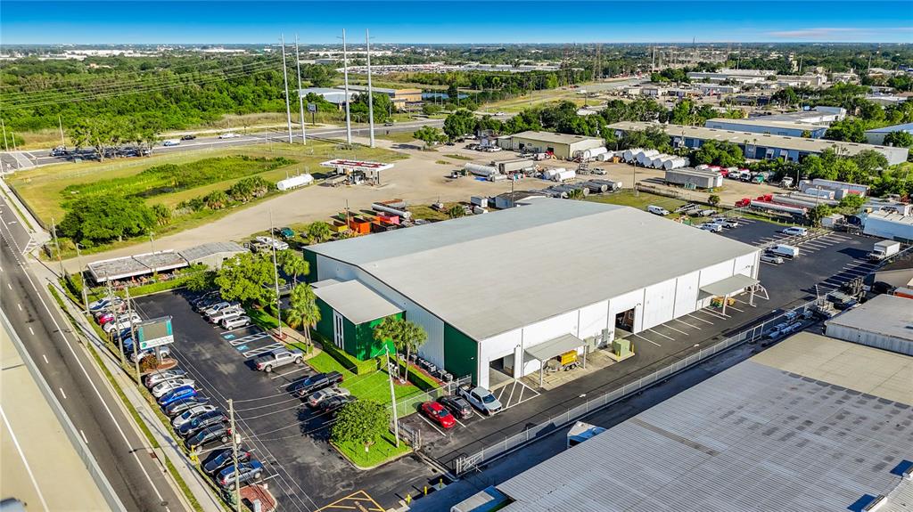 An aerial view shows a large industrial warehouse building with a parking lot and surrounding grounds — 4677 118TH AVENUE N, CLEARWATER, FL