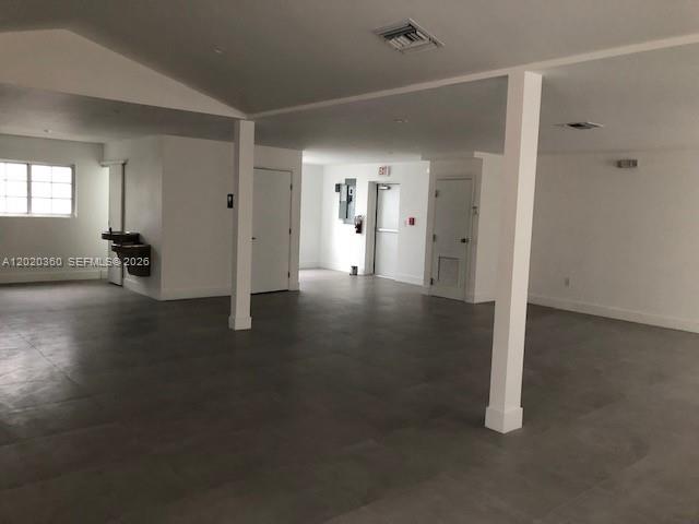 An open-plan interior space features white walls, gray tile flooring, and several doorways — 929 Collins Ave # 2A, Miami Beach FL 33139, MIAMI BEACH, FL