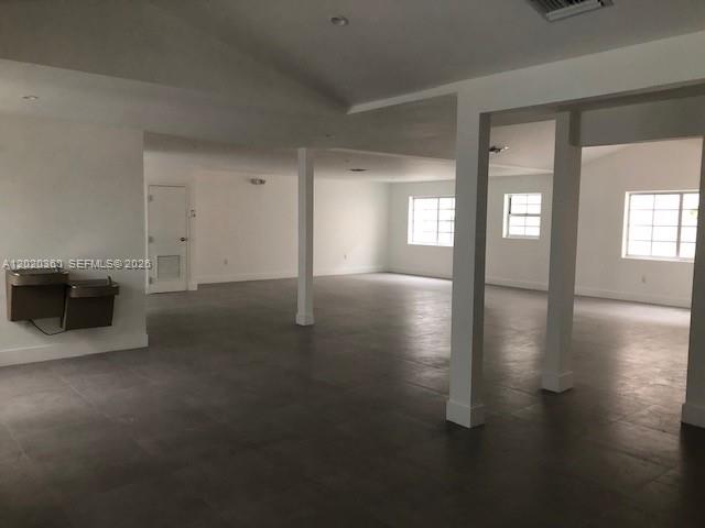 An open-plan room with white walls, gray tile flooring, and several structural support columns — 929 Collins Ave # 2A, Miami Beach FL 33139, MIAMI BEACH, FL