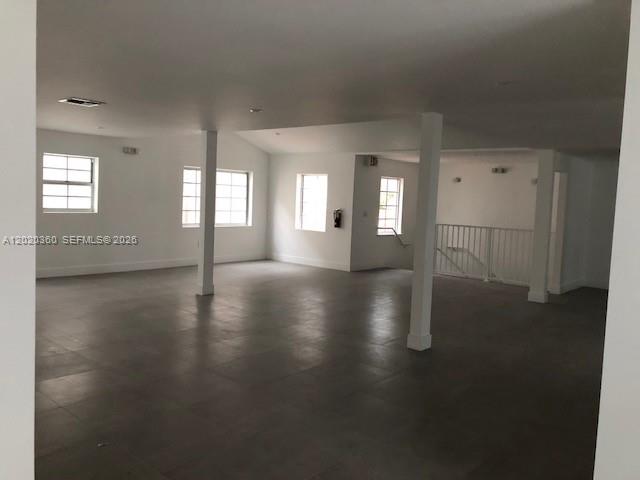 An open-plan room features white walls, dark tile flooring, and several structural support columns — 929 Collins Ave # 2A, Miami Beach FL 33139, MIAMI BEACH, FL