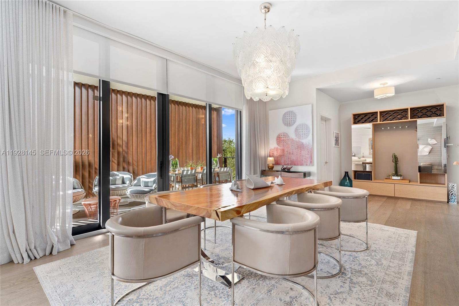 A dining room features a live-edge wood table, modern chairs, and a glass chandelier — 3581 E Glencoe St # 403, Miami FL 33133, MIAMI, FL