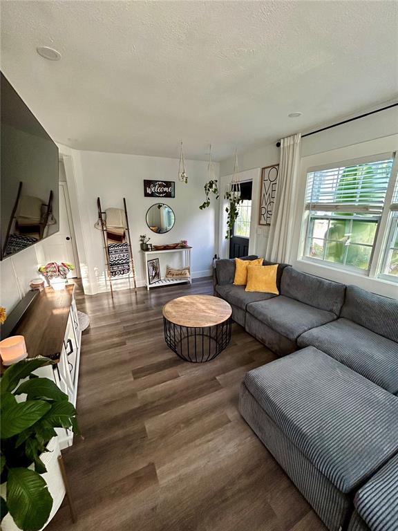 A living room features a gray sectional sofa, a round coffee table, and wood-look flooring — 3550 2ND AVENUE S, ST PETERSBURG, FL