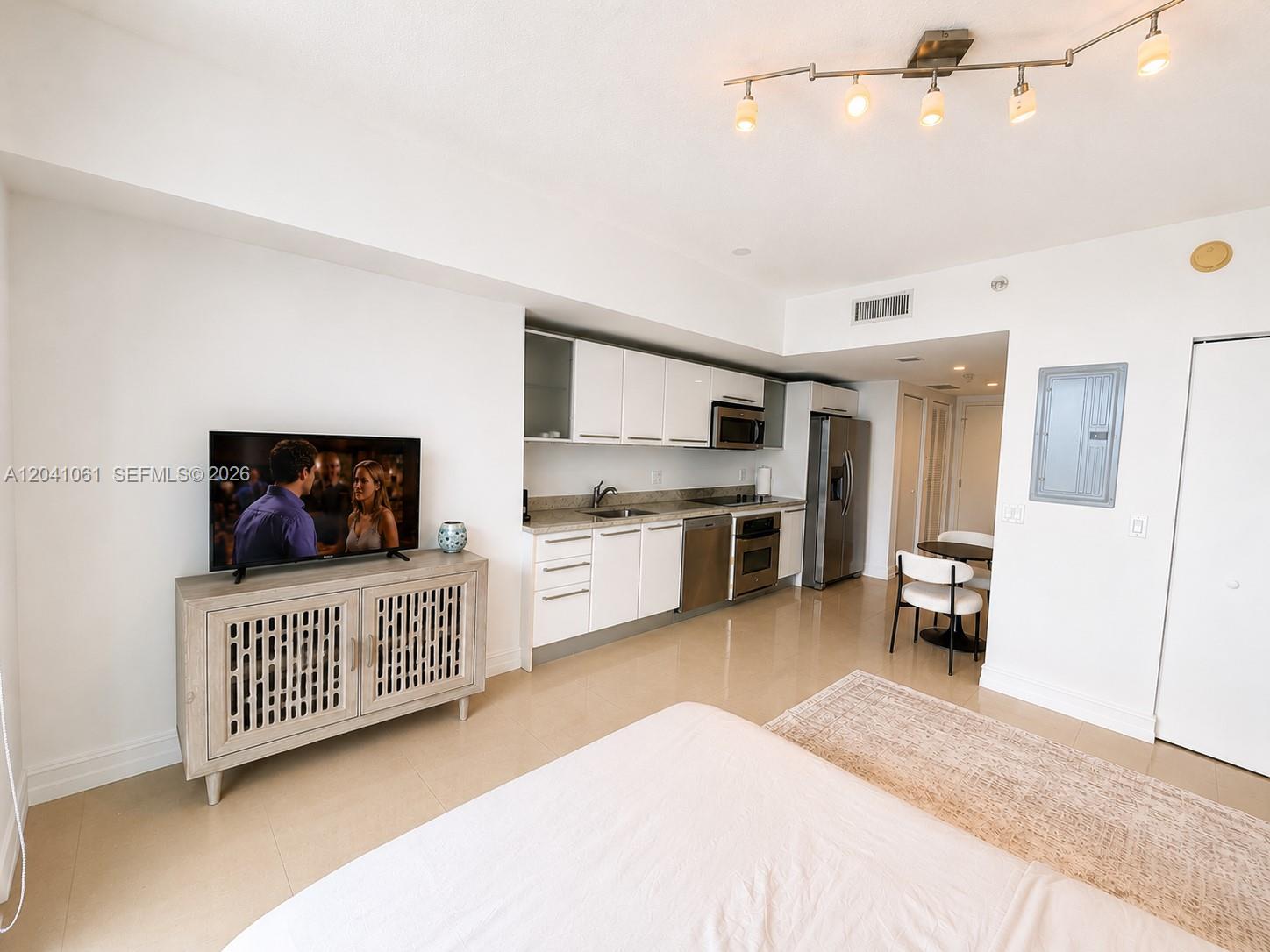 This studio apartment features a kitchenette, a television on a console, and tile flooring — 185 SW 7th St # 2706, Miami FL 33130, MIAMI, FL