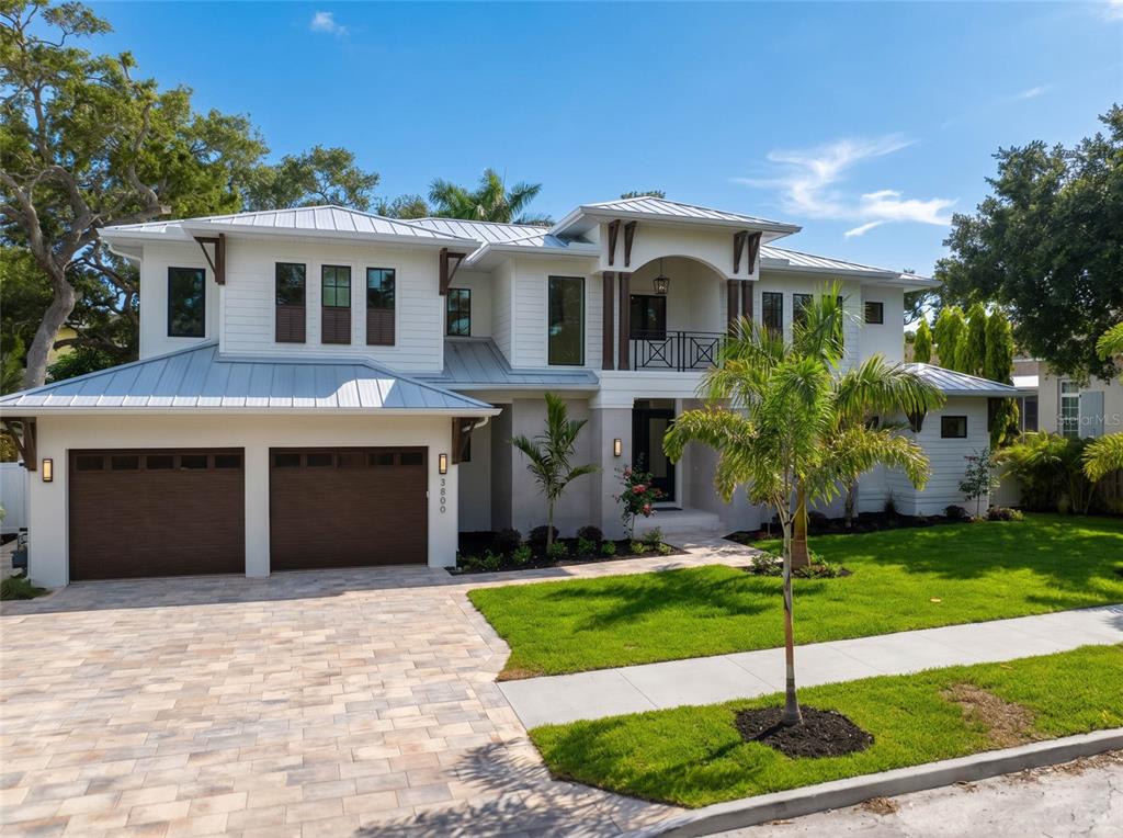 A two-story house with a metal roof, white siding, and a two-car garage — 3800 FLORES AVENUE, SARASOTA, FL