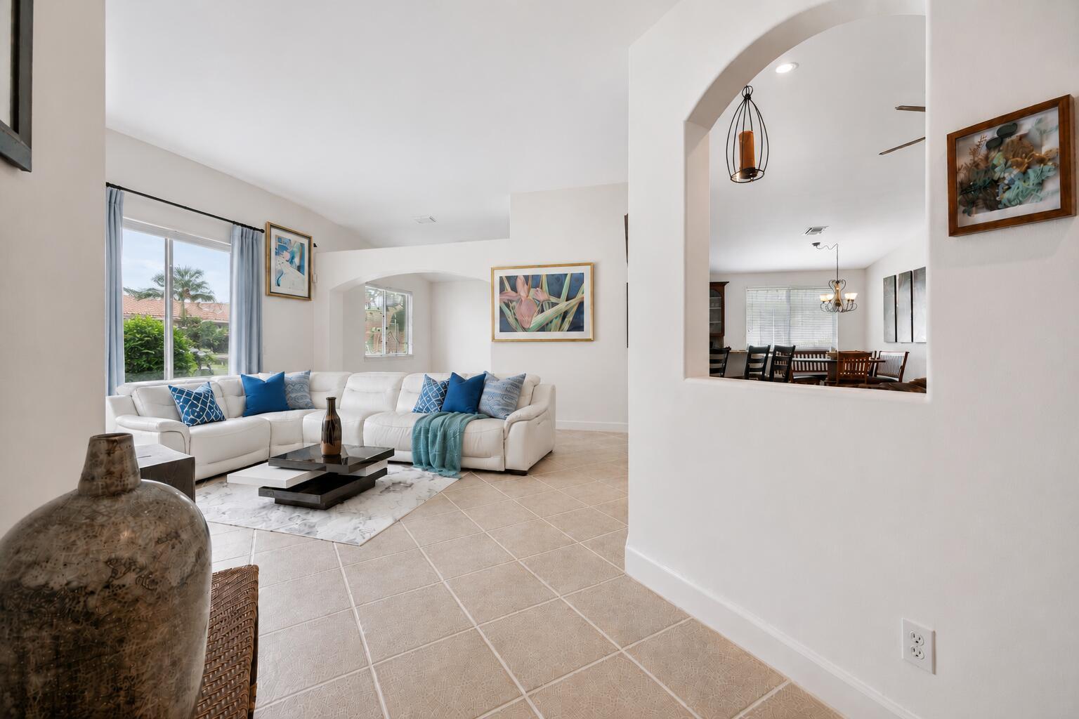 A living room with a white sectional sofa, tile floors, and an arched wall opening — 14520 SW 37th Street, Miramar FL 33027, MIRAMAR, FL