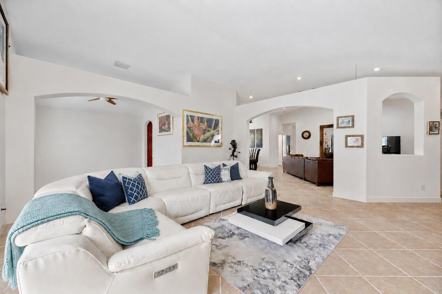 A white sectional sofa sits on a tiled floor in a bright, open-concept living room — 14520 SW 37th Street, Miramar FL 33027, MIRAMAR, FL