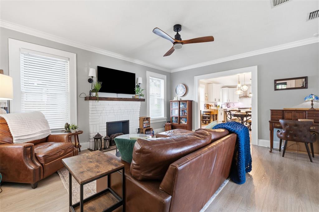A living room features a white brick fireplace, leather furniture, and a ceiling fan — 906 E PATTERSON STREET, TAMPA, FL
