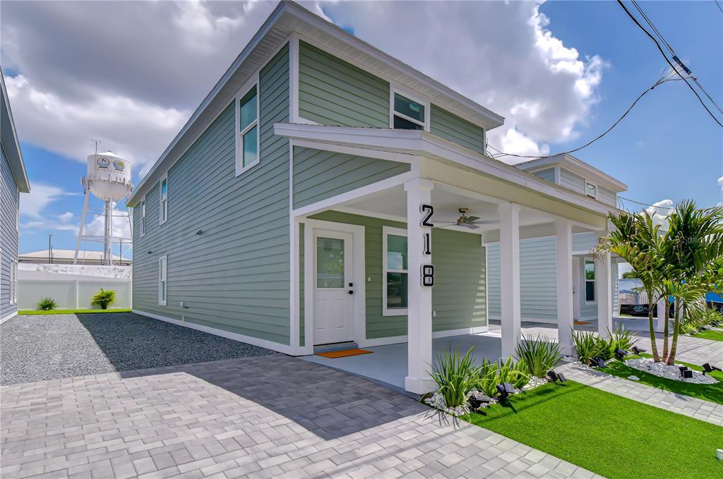 A light green two-story house with a covered front porch and a paved driveway — 218 8TH AVENUE DRIVE W, BRADENTON, FL