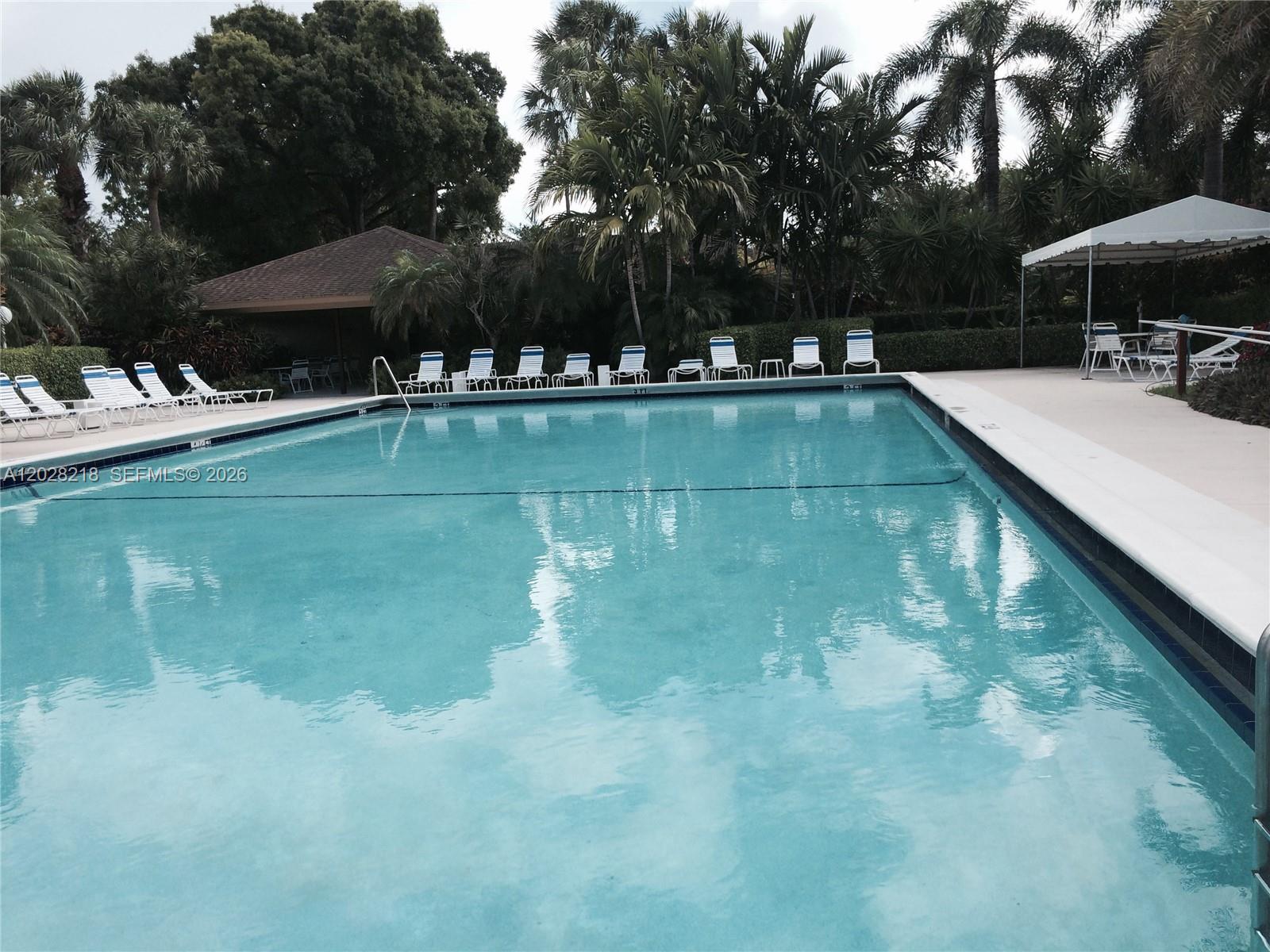 A swimming pool with lounge chairs on the deck and a gazebo in the background — POMPANO BEACH, FL