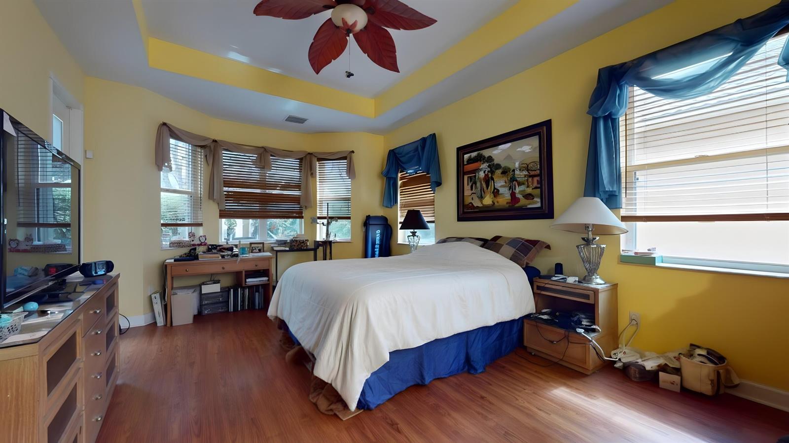 A bedroom features yellow walls, a ceiling fan, a bed, and windows with blue valances — 10072 Armani Drive, Boynton Beach FL 33437, BOYNTON BEACH, FL