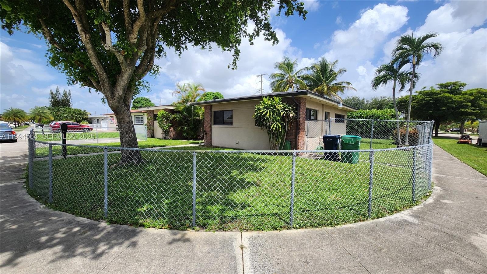 A single-story house with a chain-link fence and a large tree in the front yard — 6241 NW 110th St, Hialeah FL 33012, HIALEAH, FL
