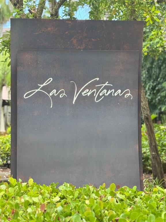 A metal sign with the words Las Ventanas stands behind a green hedge — 7000 BAHIA BEACH BLVD, RIO GRANDE, PR