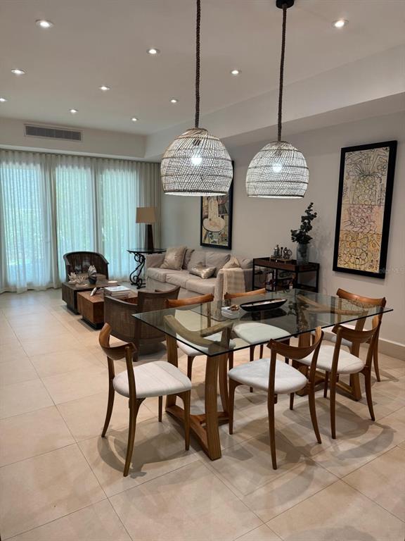 A dining area with a glass table and chairs sits in front of a living room — 7000 BAHIA BEACH BLVD, RIO GRANDE, PR