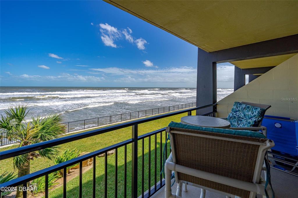 A balcony with patio furniture overlooks a grassy lawn and the ocean — 2301 S ATLANTIC AVENUE UNIT 236, DAYTONA BEACH, FL