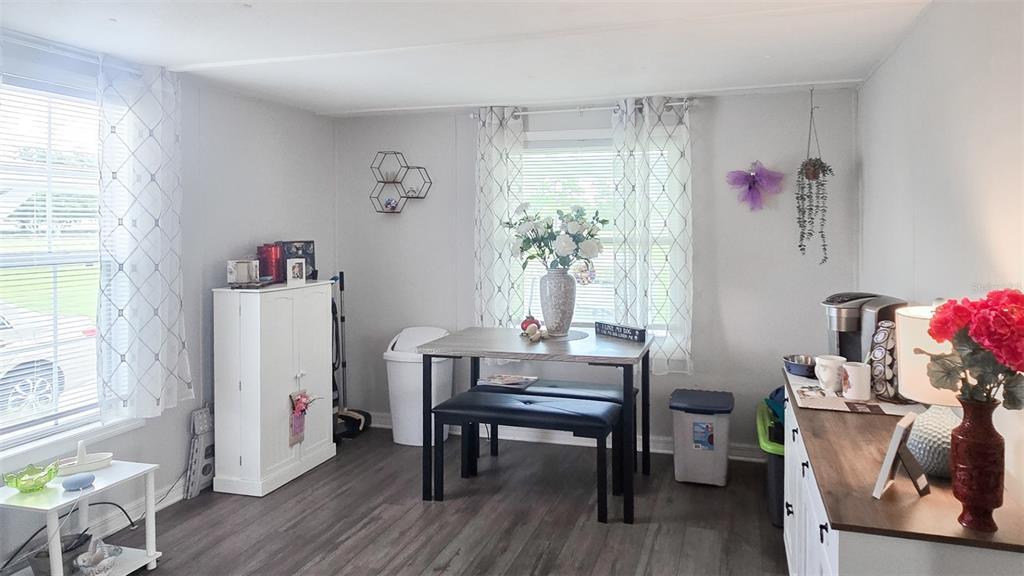 A dining area features a table with two benches, a white cabinet, and gray flooring — 177 FOREST LAKE DRIVE, COCOA, FL