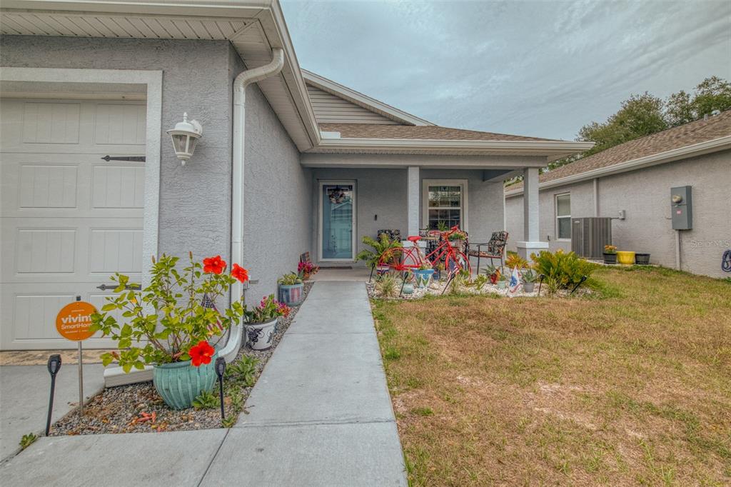 A gray stucco house exterior features a front porch, a walkway, and a garage — 10541 S DREW BRYANT CIRCLE, FLORAL CITY, FL