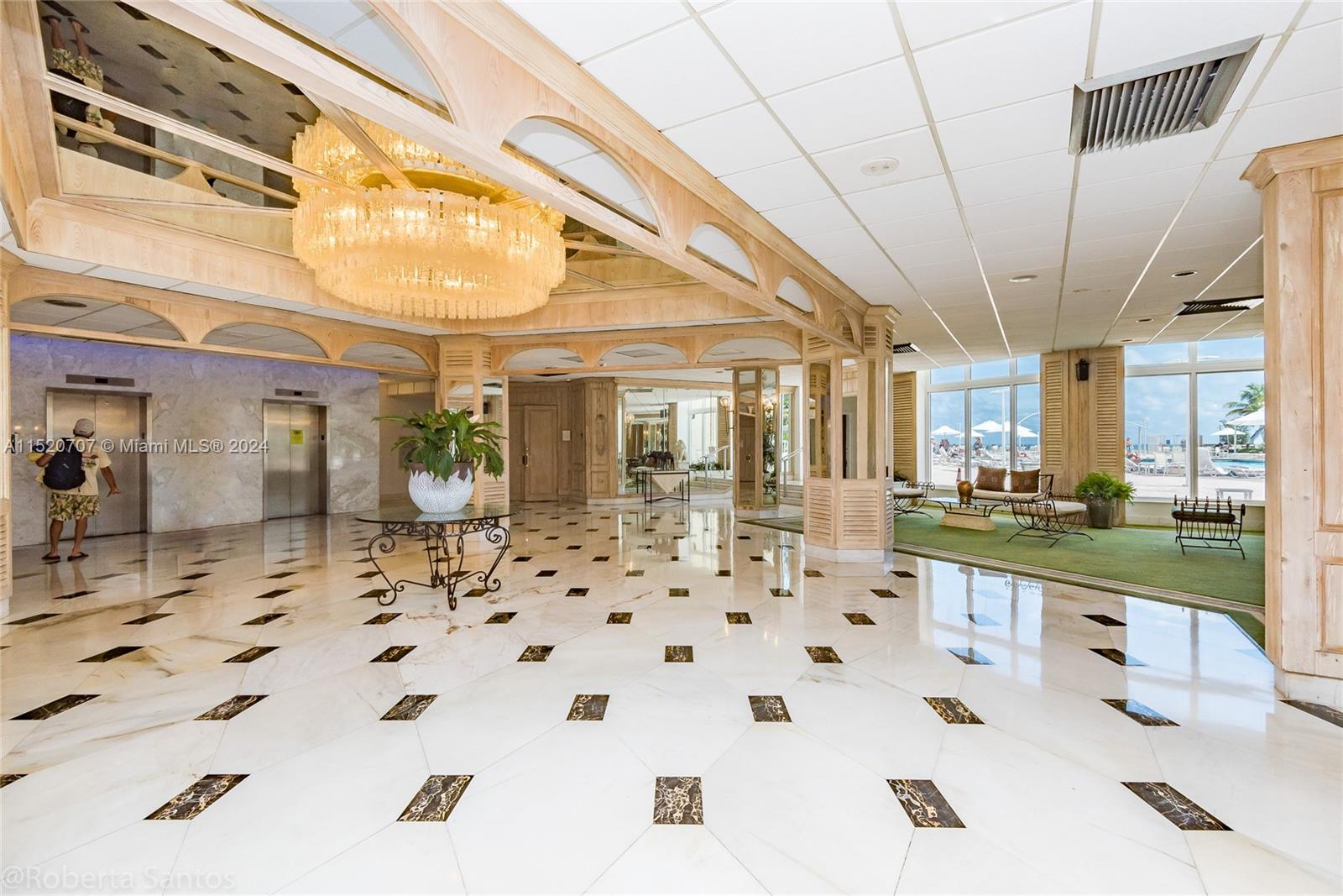 A spacious building lobby features marble floors, a large crystal chandelier, and floor-to-ceiling windows — 3180 S Ocean Dr # 422, Hallandale Beach FL 33009, HALLANDALE BEACH, FL