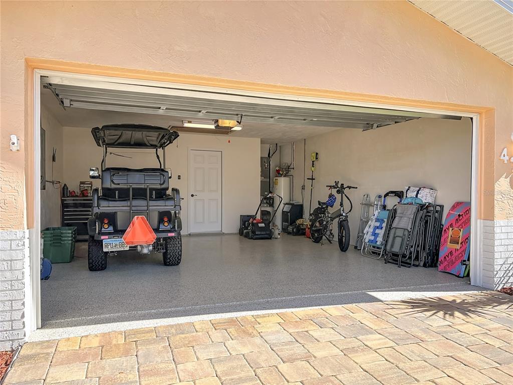 A single-story house with a peach-colored exterior, a two-car garage, and a brick paver driveway — 4761 RIVERGLEN BOULEVARD, PONCE INLET, FL